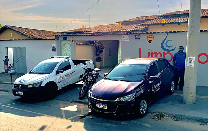 Fachada da sede da Limpecol em Goiânia, com a marca aplicada na parede e os veículos da empresa estacionados na frente