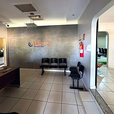 Recepção da Limpecol Serviços Gerais, com a marca aplicada na parede e espaço de espera para clientes